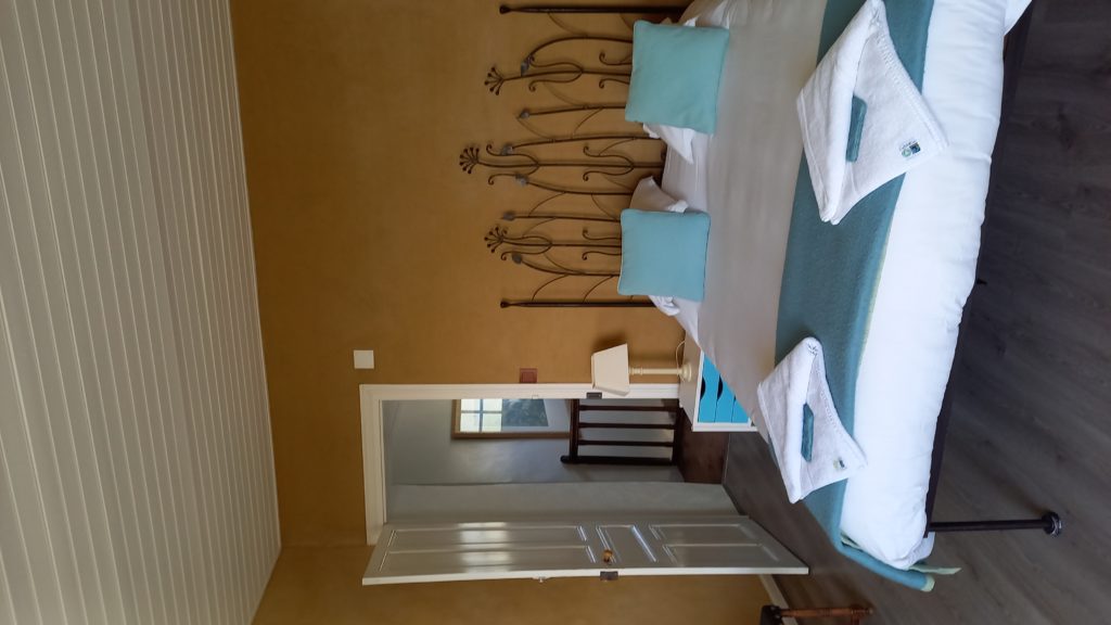 lit double de la chambre hôtes bleue avec porte d'entrée